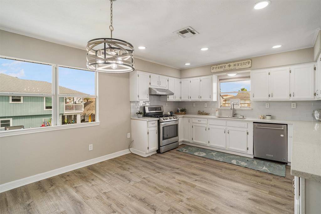 View of the kitchen with a window over the sink. There are plenty of real wood cabinets for storage