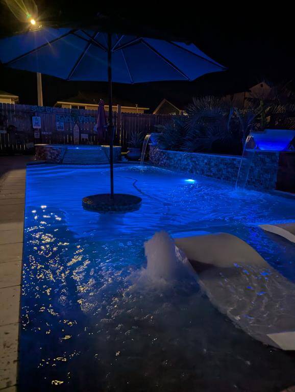 View of the pool at night with the lights and bubble effect