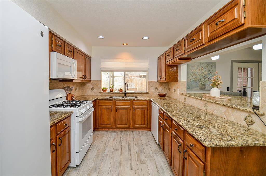 Granite countertops, rich wood cabinetry, and updated lighting make this kitchen a chef’s dream.