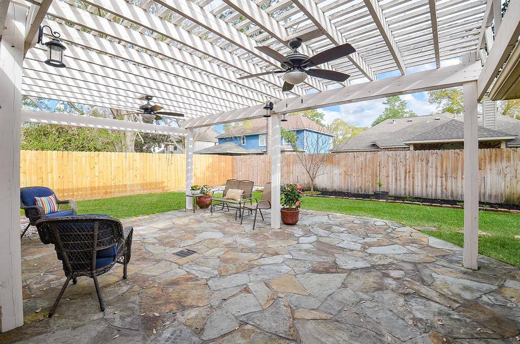 A spacious, private backyard with a pergola-covered patio.