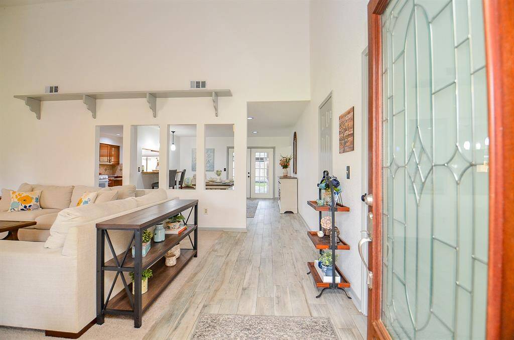 Step through the elegant glass-paneled front door into a bright and airy living space.