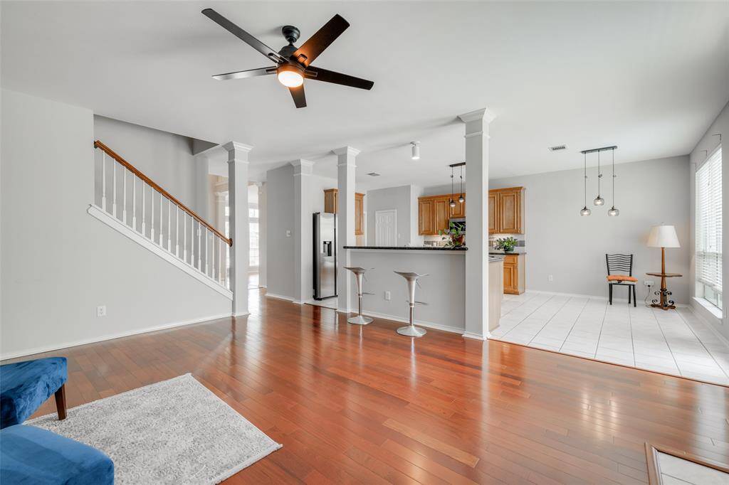 Living room featuring a new black modern ceiling fan with light fixture, tiled gas wood burning fireplace, enjoy entertaining with friends at the breakfast bar open to the kitchen.