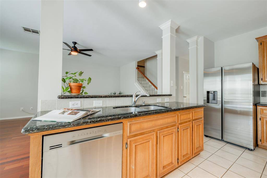 Gorgeous kitchen offers tile floors, tile backsplash, granite counter tops, granite island workspace, new electric cooker, new SS built-in microwave, walk-in pantry, opens to the breakfast room.