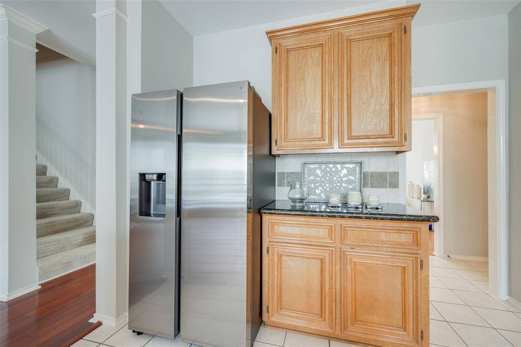 Gorgeous kitchen offers tile floors, tile backsplash, granite counter tops, granite island workspace, new electric cooker, new SS built-in microwave, walk-in pantry, opens to the breakfast room.