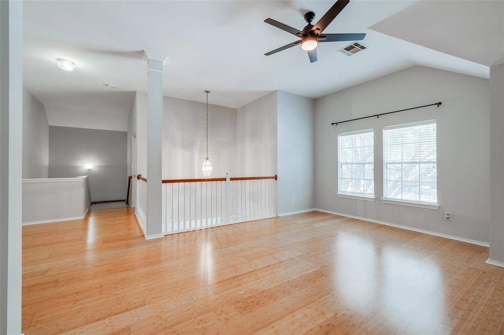 Game room upstairs offering accented by Bamboo wood floors, raised ceilings, new ceiling fan with light fixture and open to the entry below.