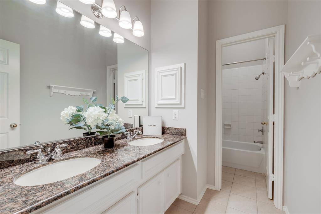 Full hall bath with double sinks, granite counter tops and a tub/shower.