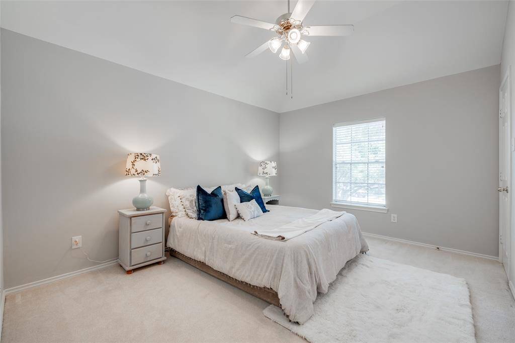 Secondary bedroom offers raised ceilings, ceiling fan with light fixture, two inch window blinds and nice closet space.