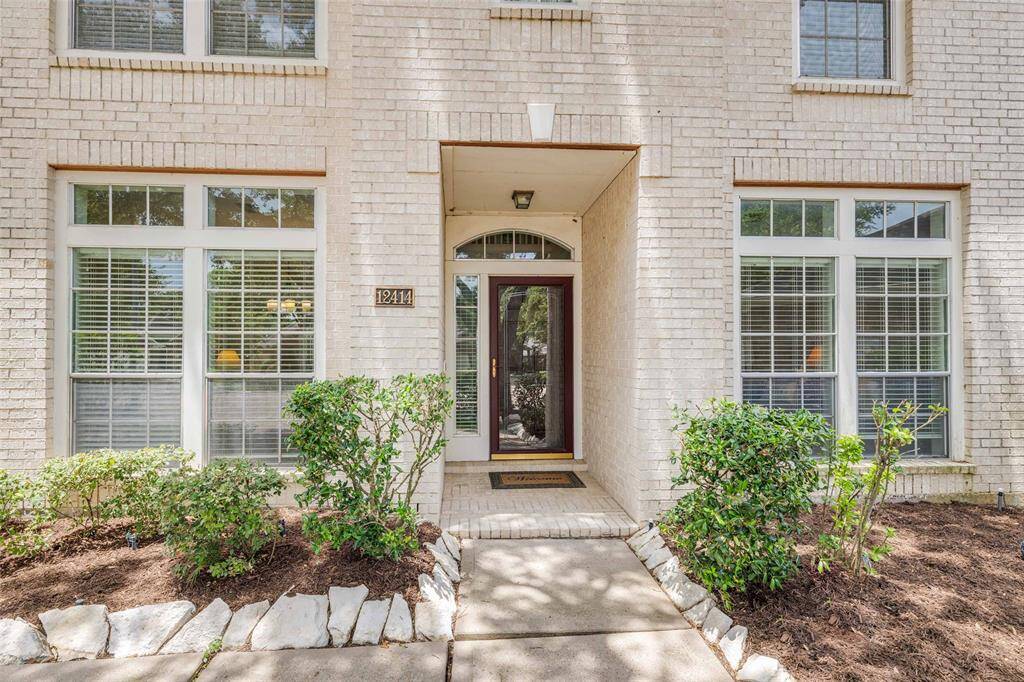 Front view of this exceptional home located in a gated lake community, home has a storm door