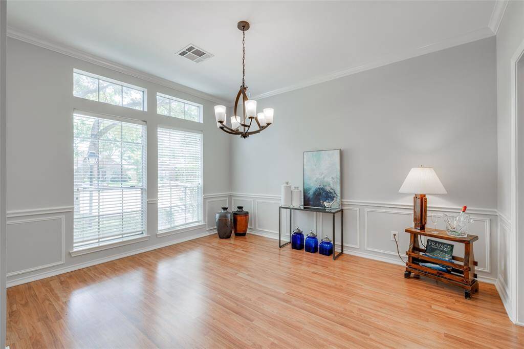 Dining room enhanced by hardwood laminate floors, crown molding with access to the kitchen, new black dining room chandelier