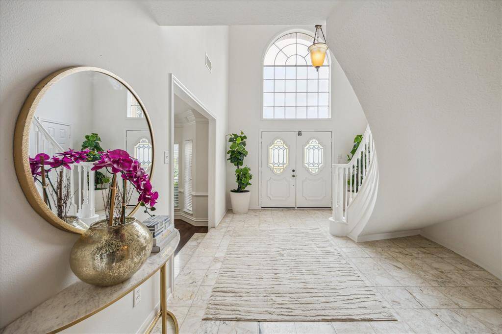 Grand 2 story entry foyer with arched window and sweeping staircase