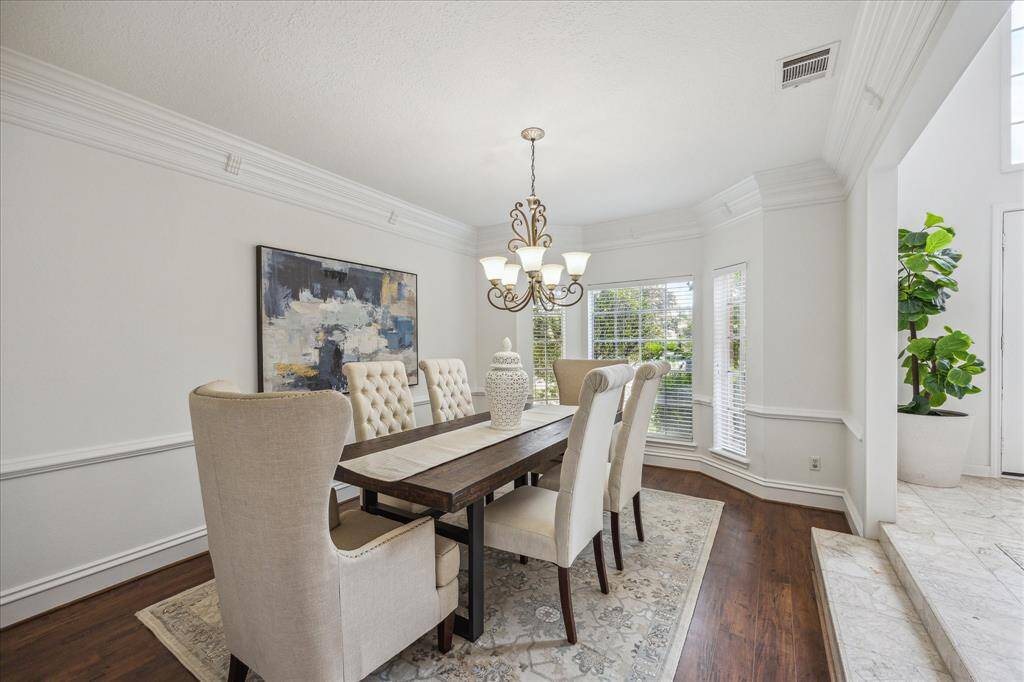 Classic elegant dining room with stately crown molding, adjacent to the kitchen