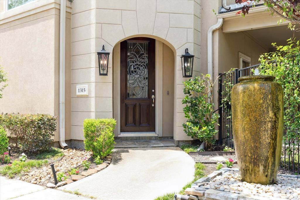 The charming entry with fountain and gated entry to the side garden.