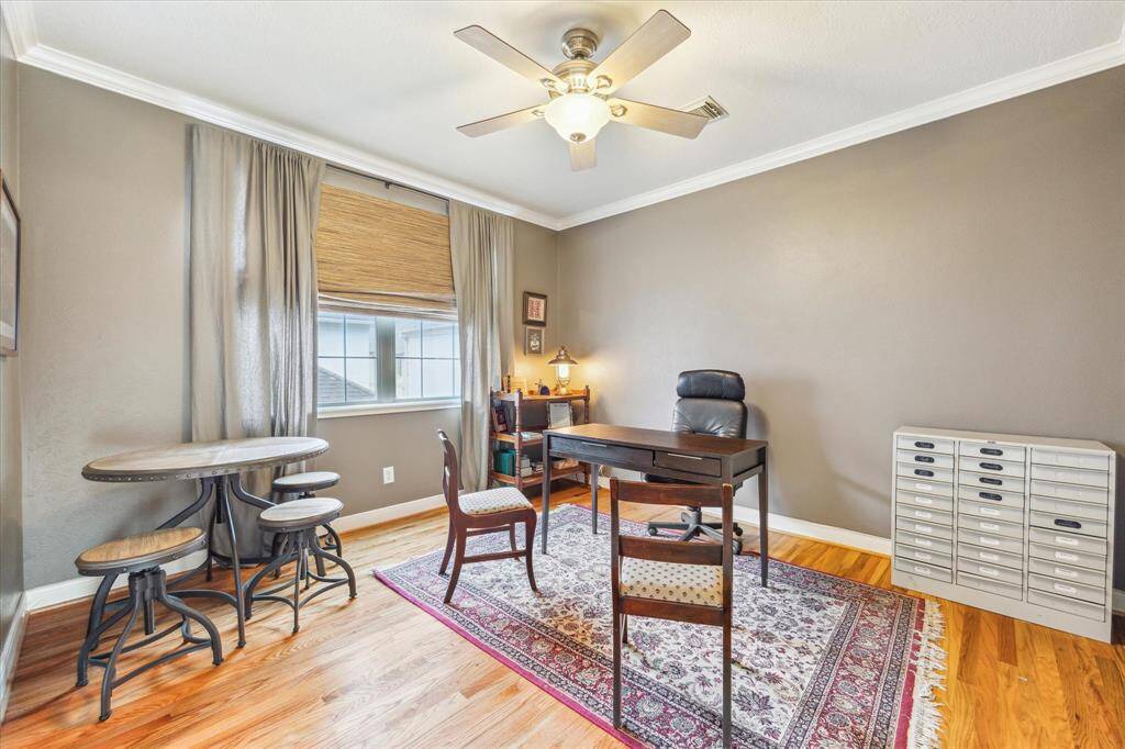 The bedroom with en-suite bath is currently being used as an office. The room features hardwood floors and built-in cabinets.