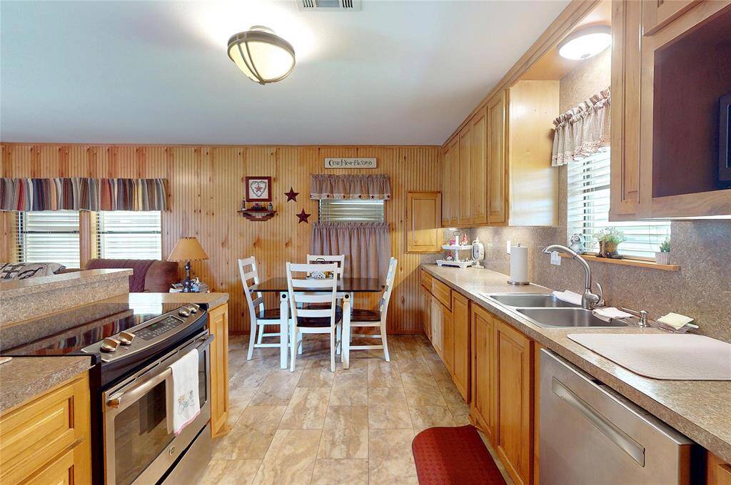 Custom cabinets in kitchen include slide out trash drawer, spice rack and built in pantry