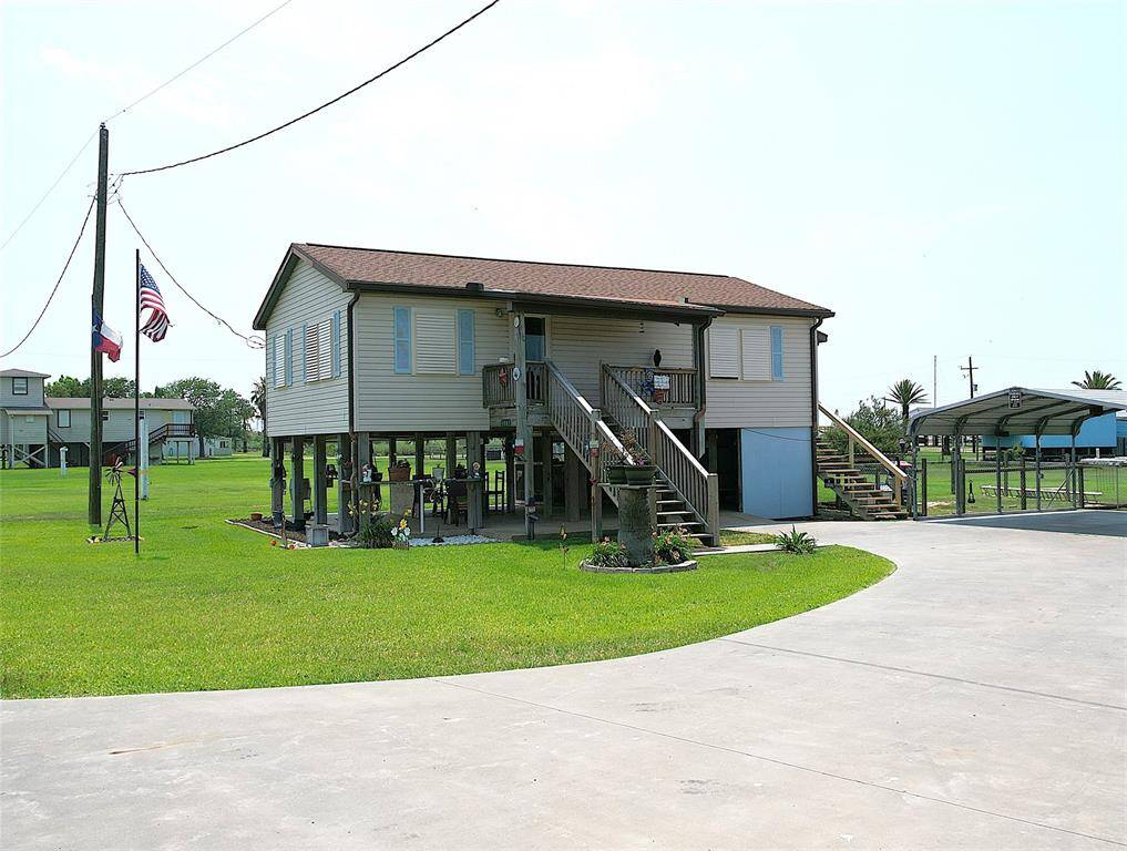 Extra wide half circle driveway leading to carport beneath the home