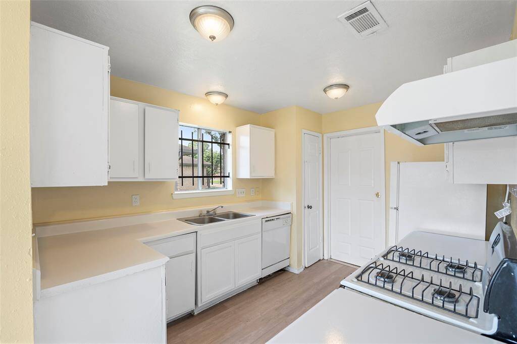 This kitchen features bright white cabinets and pretty countertops ideal for meal preparation and storage!