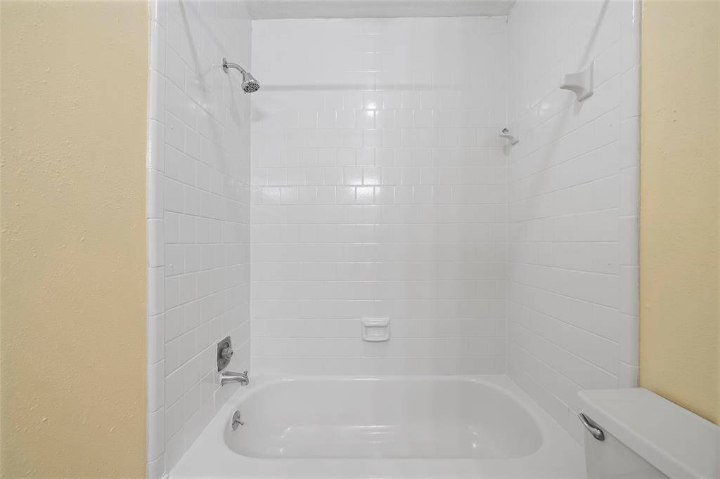 This bathroom features a shower/tub combination complete with tile surround!