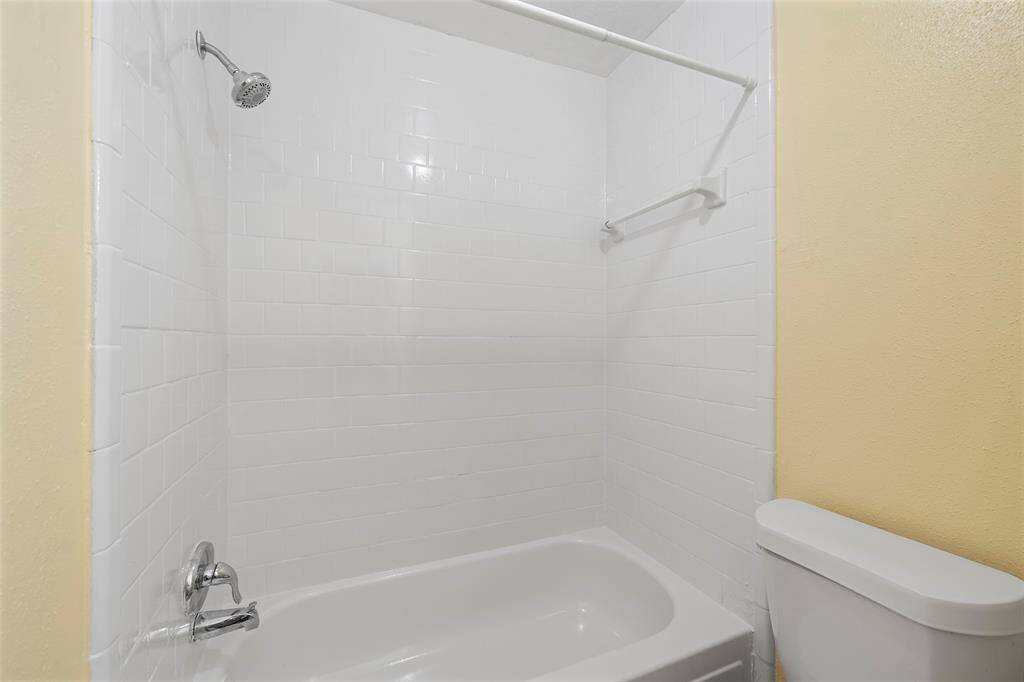 This bathroom features a shower/tub combination complete with tile surround!