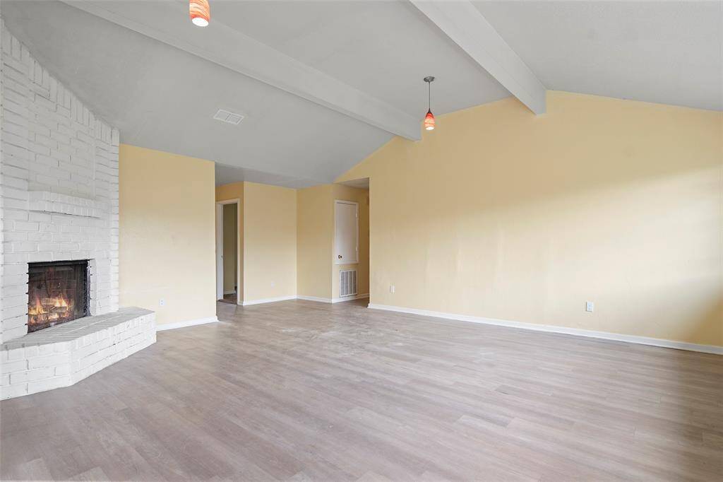 A corner brick fireplace with hearth will surely warm the hearts of all that gather here!