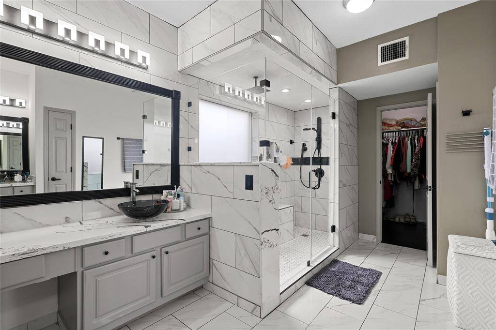 Primary Ensuite First Floor:  His & Her separate vanities, oversize walk-in shower has dual rain shower heads & seating bench & walk-in closet