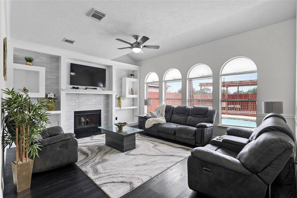 Family room with a plethora of windows overing looking the swimming pool & cabana area.