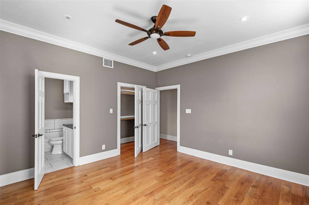 This spacious secondary bedroom with hardwood flooring, is located in the first floor. It features a walk-in closet and an en-suite bathroom.