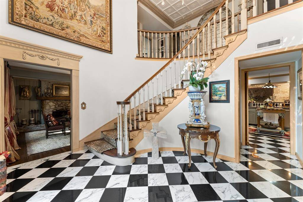 The front foyer features marble floors and a grand staircase