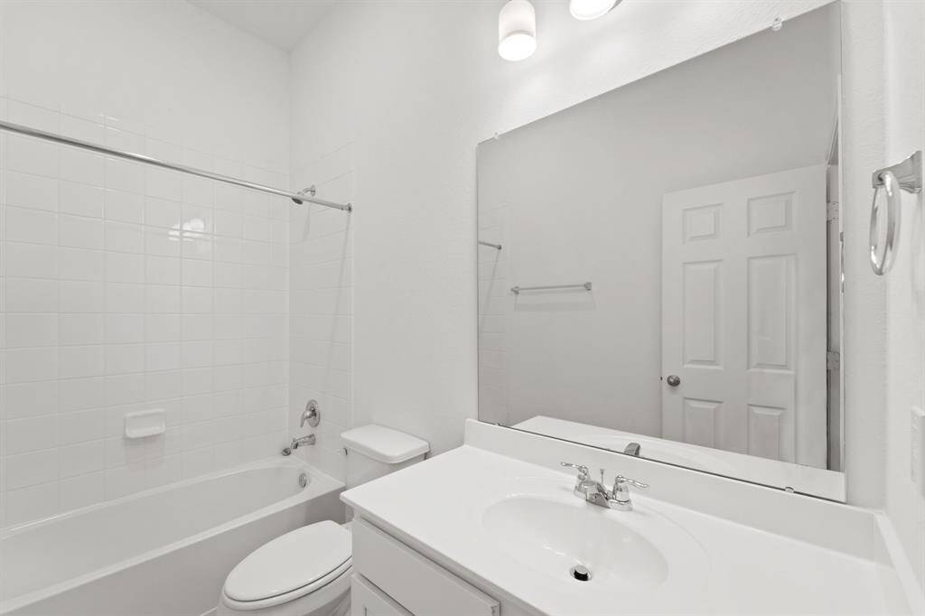 The secondary bath features tile flooring, white cabinetry and light countertops and a shower/tub combo. Perfect for accommodating any visiting family and friends.
