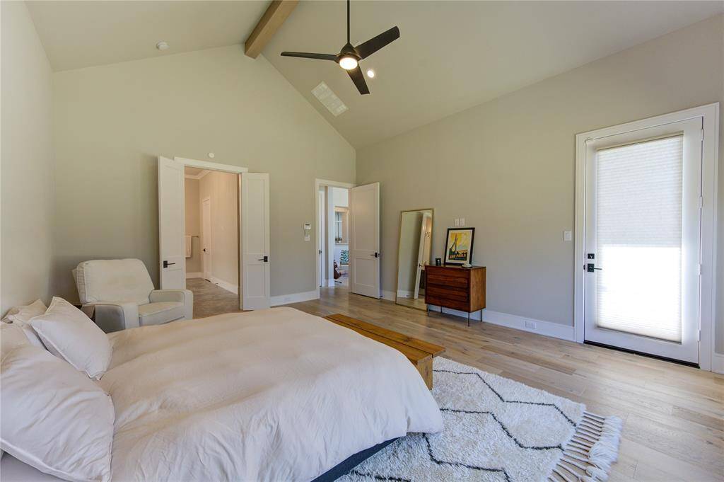 Luxurious master bedroom with soaring ceilings and direct pool access.