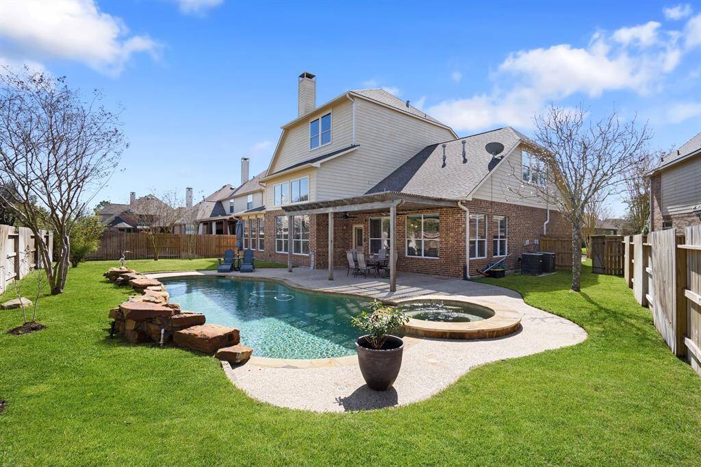 Backyard with plenty of grassy area around the pool and enough hardscaping for gathering areas.