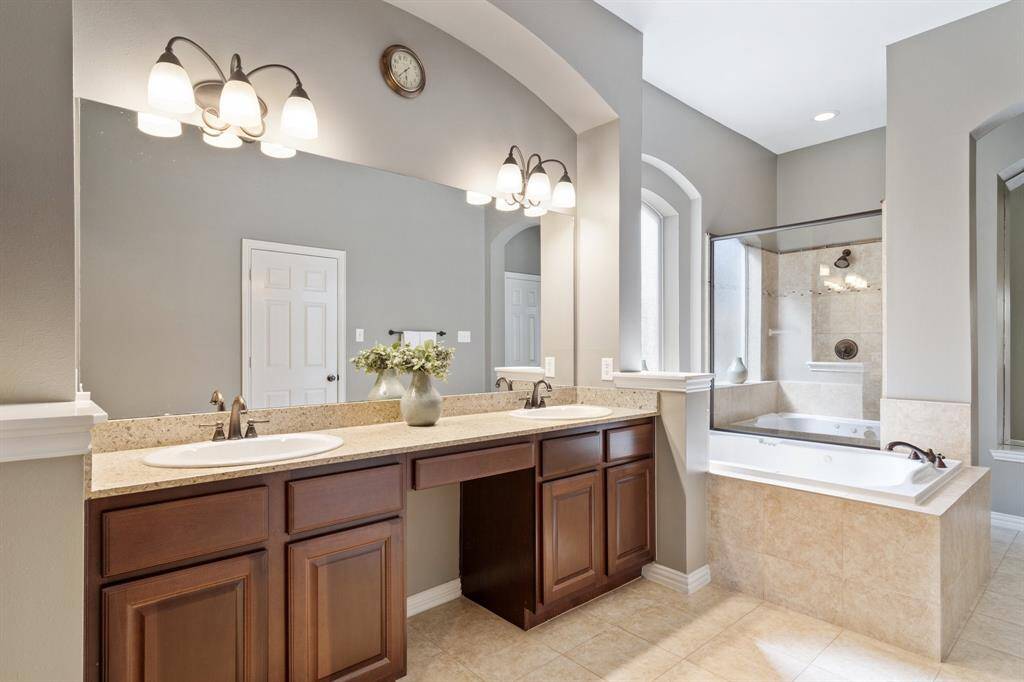 Dual sinks with sitting vanity area and separate tub and shower.
