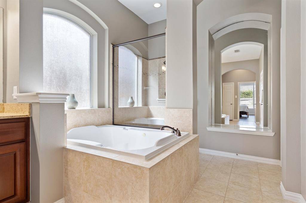 Closer view of the tub and shower with beautiful arches for some added architectural design.