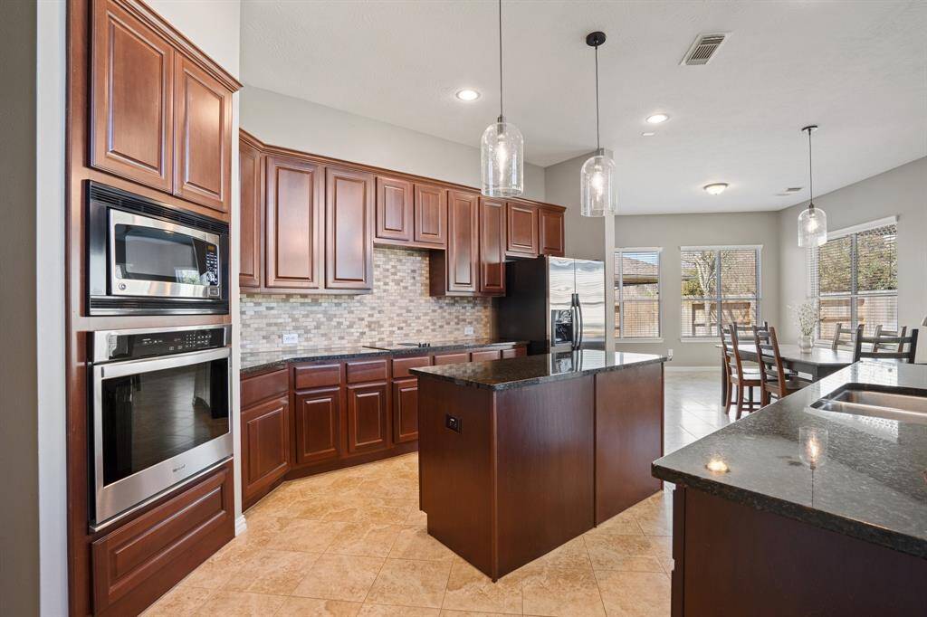 Functional and spacious kitchen with serving/prepping island and lots of cabinets and countertops.