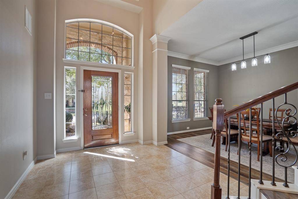 Entryway with high ceilings opens immediately into the formal dining room complete with crown molding.