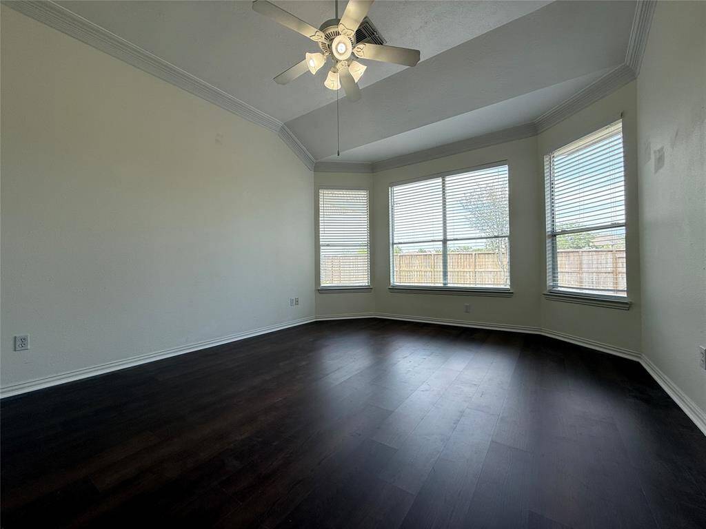 Enjoy a bright primary bedroom with tall ceilings, LVP floors, bay window, ceiling fan, and French door entry to the en suite bathroom
