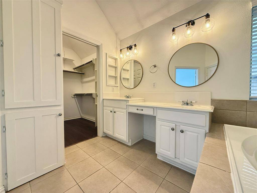 This primary bath features generous storage and a spacious closet for all your needs.