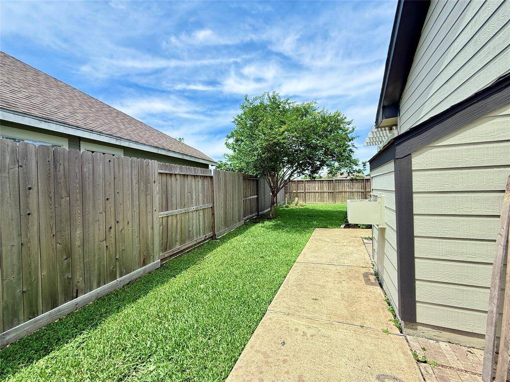 Concrete pathway guides you from the patio door to the pergola and roomy backyard.