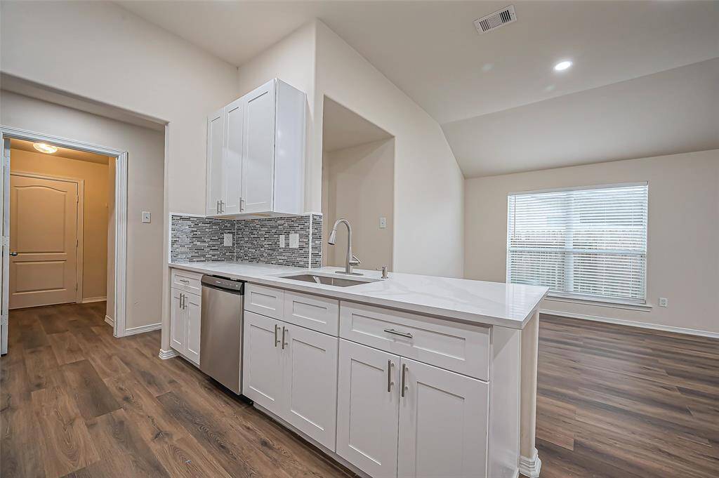 The kitchen overlooks the open dining and family room area, creating a spacious and inviting atmosphere. High ceilings enhance the sense of space, while continuous LVP flooring (2024) flows seamlessly throughout. Recessed lighting (2024) adds a modern touch, brightening the entire area. Perfect for both everyday living and entertaining!