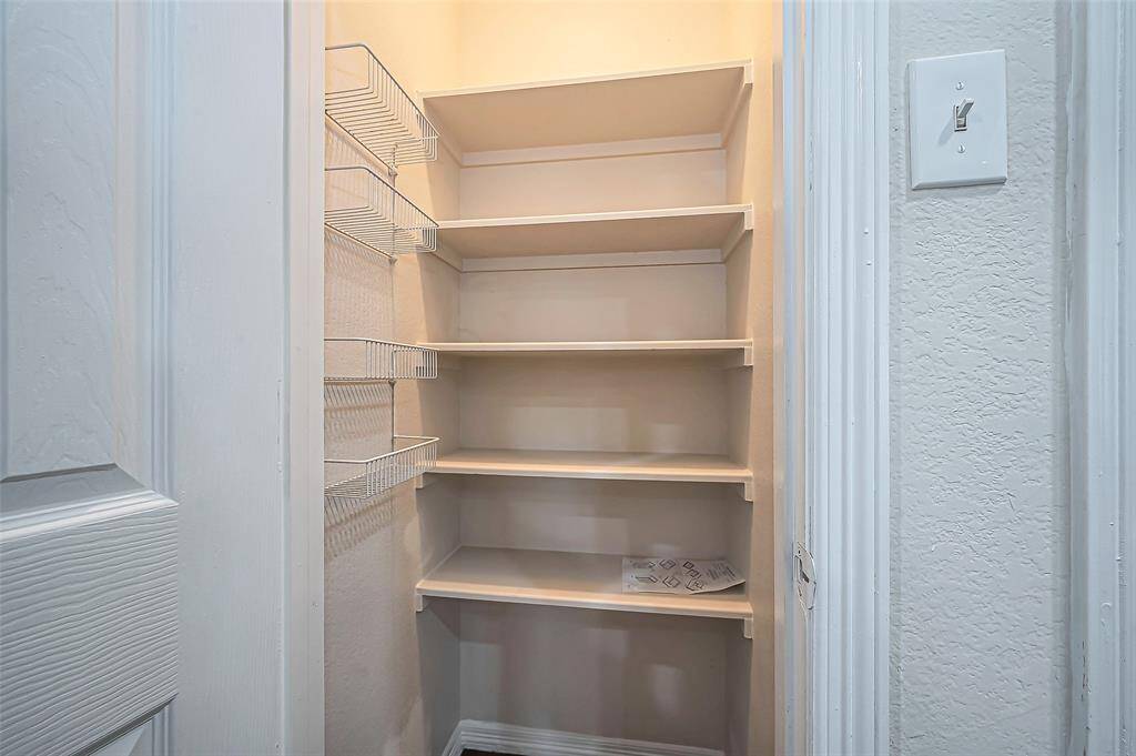 Just off the kitchen, you'll find a lighted walk-in pantry with plenty of shelves and wire racks, offering ample storage space for all your pantry essentials.