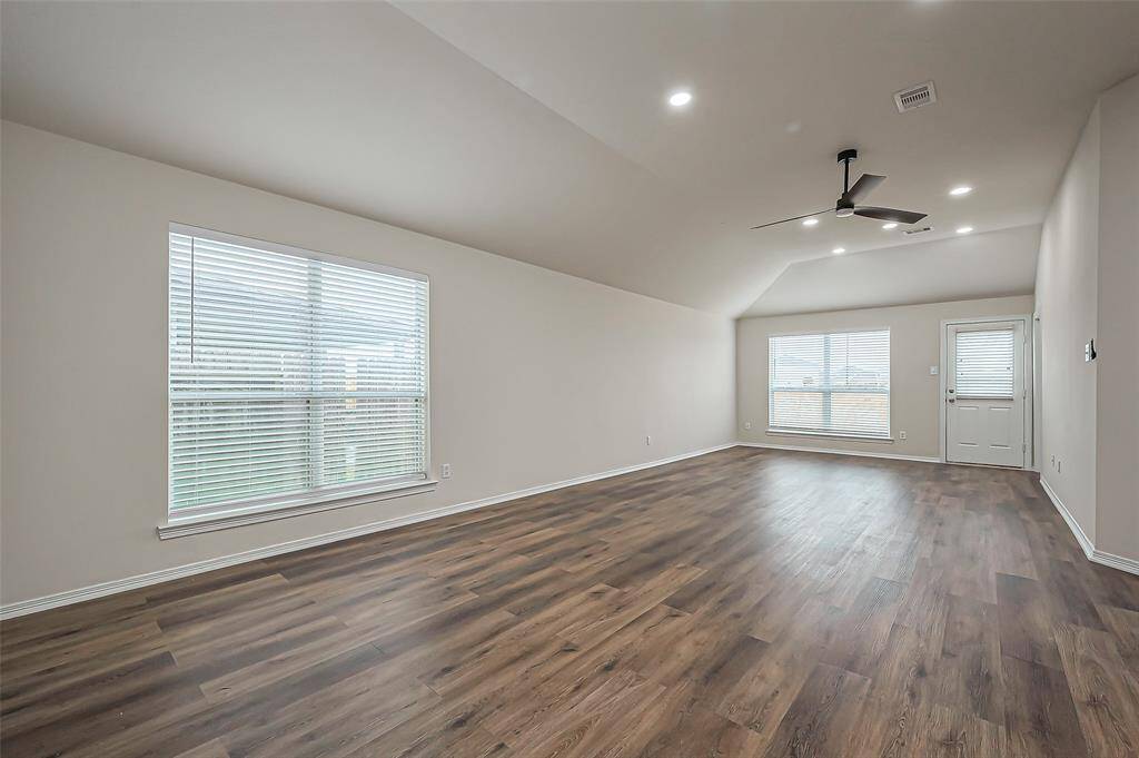 The spacious family room (31.6 x 13.2) features energy-efficient double pane windows with 2-inch blinds, filling the space with natural light. High ceilings add to the sense of openness, offering plenty of versatility for decorating. There's ample room for a sectional sofa or other large cozy furniture. You could easily divide the room into a formal dining area at one end and a living space at the other.