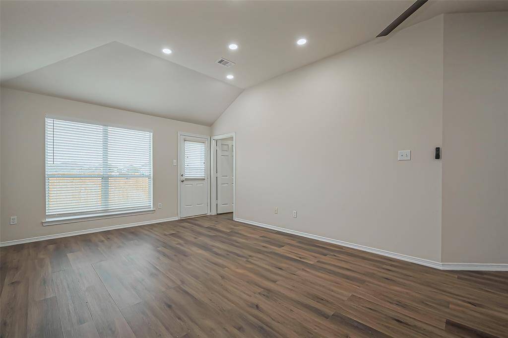The back part of this expansive area was likely intended as the living space, with a large window overlooking the backyard. Door leads to the patio, perfect for outdoor enjoyment. The ceiling fan, which includes a remote for added convenience, helps keep the space comfortable. With plenty of wall space, this area is ideal for displaying a big screen TV or entertainment center. The durable, water-resistant LVP flooring is perfect for families with children and pets, as it wears well and is easy to maintain.