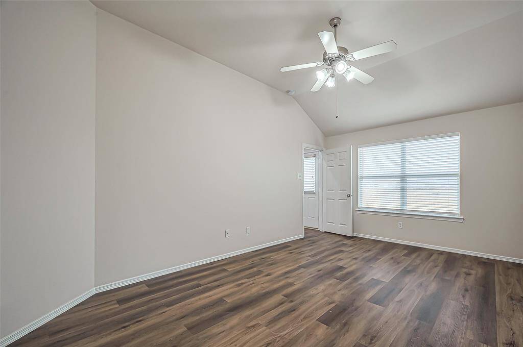 The owner's suite features a large window with 2-inch blinds, offering a serene view of the backyard. Abundant natural light fills the space, creating a bright and peaceful retreat.
