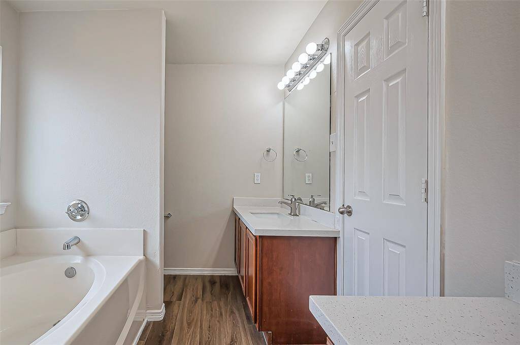 A door on the right opens into the ensuite bathroom (11.2 x 7.11), featuring two separate sink vanities for added convenience. The space is finished with durable LVP flooring, and a private area for the commode ensures additional privacy.
