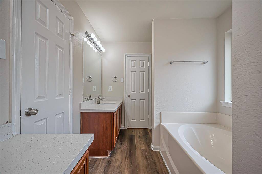 From the opposite direction, you'll find the second sink vanity, a relaxing garden soaking tub, and a separate shower. A spacious walk-in closet provides ample storage, completing this well-appointed ensuite bathroom.