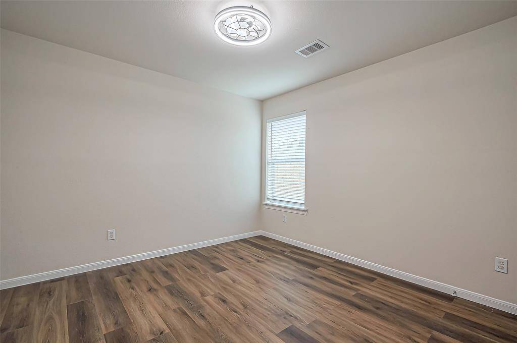Bedroom #3 measures 10.11 x 10.11 and features a window with 2-inch blinds that overlooks the side yard. A modern ceiling fan with a remote (2024) ensures comfort, while the LVP flooring provides durability and easy maintenance.