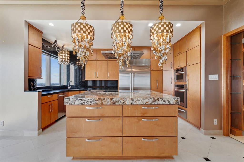 Abundant storage, granite counters, custom cabinetry, SubZero and large window at kitchen sink.