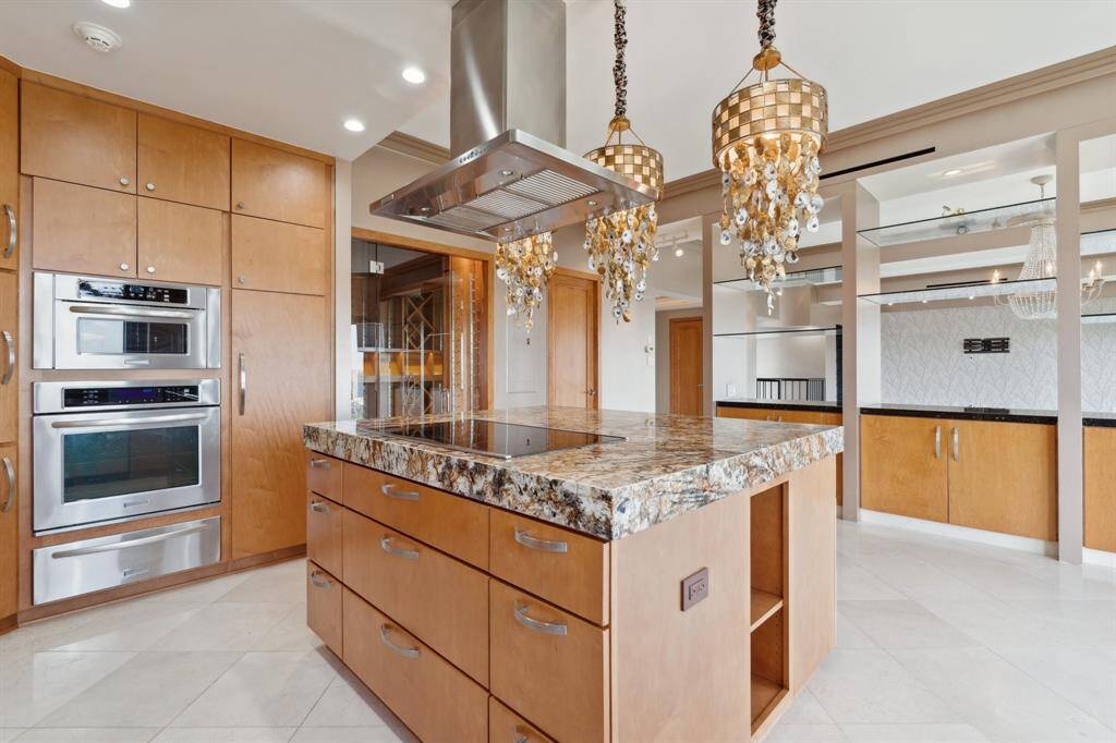 Island kitchen with stainless appliances including warming drawer and open to the breakfast room with the living areas beyond.
