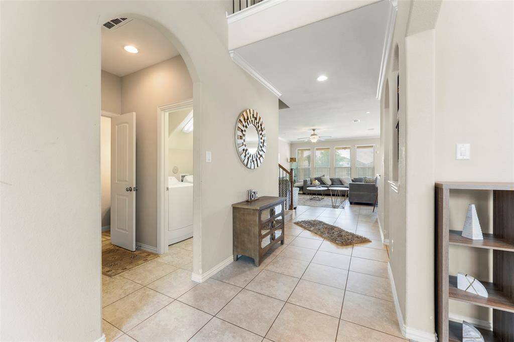 Formal Dining has Large Window overlooking Cul-De-Sac, Elegant Crown Molding, Neutral Tile Floors, and Decorative Niche.