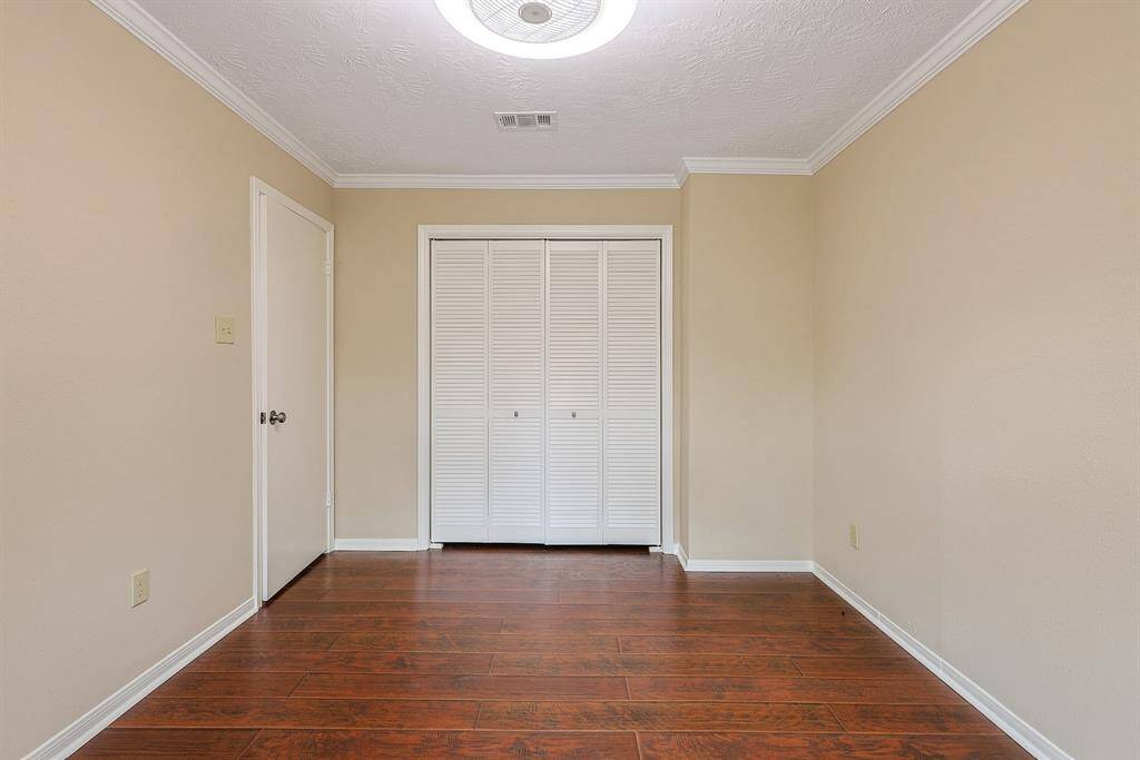 This room includes a closet with louvered doors and a simple, clean design.