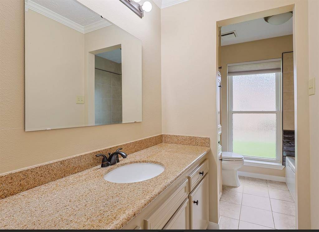 Elegant second bathroom with a spacious layout, featuring a sleek vanity, modern fixtures, and abundant natural light.Freshly tiled jetted tub (never used)